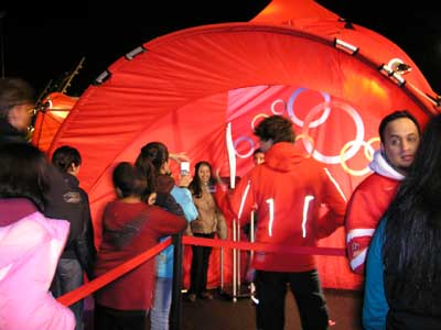 People getting their photo taken with the 2010 Winter Olympics Torch 